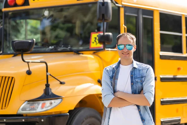 Een gelukkige mannelijke leraar in de buurt schoolbus — Stockfoto