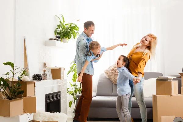 Familia feliz con cajas de cartón en casa nueva en el día de mudanza. —  Fotos de Stock