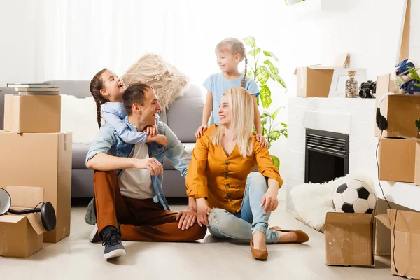 Familia feliz con cajas de cartón en casa nueva en el día de mudanza. —  Fotos de Stock