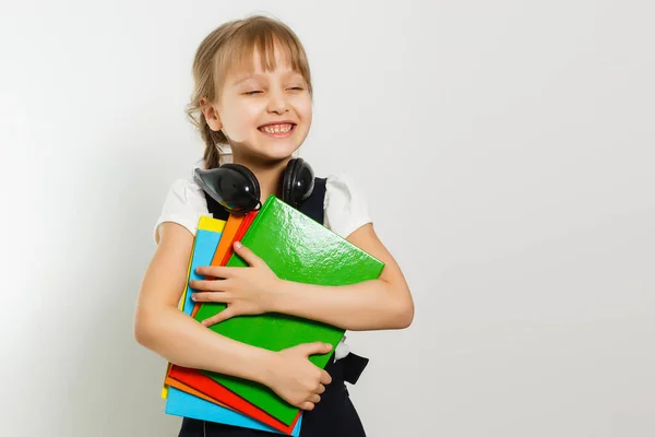 Blond skolflicka håller stor bok, skjuta över vit bakgrund — Stockfoto