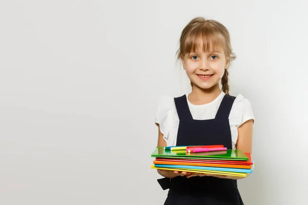 Szőke iskolás lány tart nagy könyvet, lő át fehér háttér — Stock Fotó