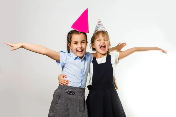 Duas meninas de aniversário em camisa azul escola uniforme vestidos chapéu isolado no fundo branco crianças estúdio retrato. Infância crianças educação conceito de estilo de vida. Mock up espaço de cópia — Fotografia de Stock
