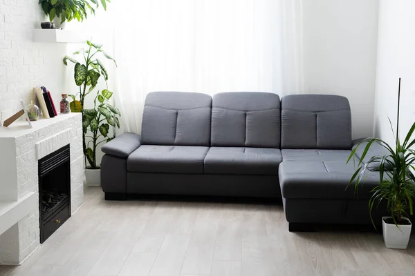 Szara sofa przy kominku w salonie — Zdjęcie stockowe