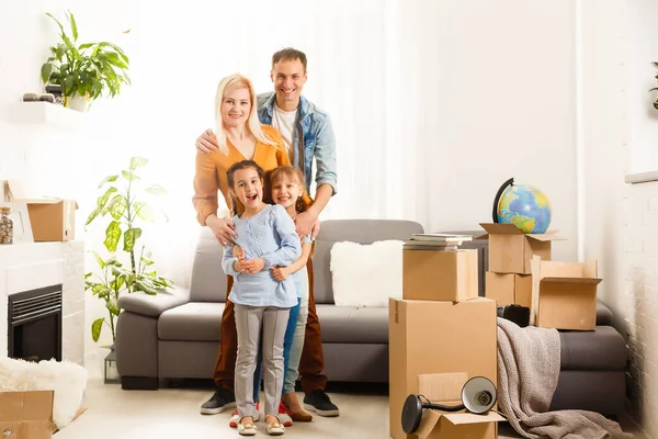 Familia feliz mudándose a casa con cajas alrededor —  Fotos de Stock