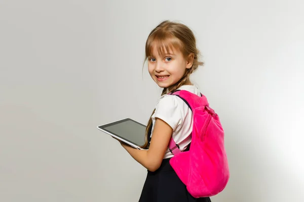 Liten blond skola flicka med ryggsäck väska porträtt isolerad på vit bakgrund — Stockfoto