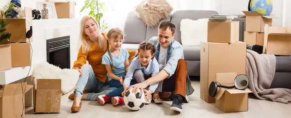 Familia feliz con cajas de cartón en casa nueva en el día de mudanza. —  Fotos de Stock