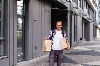 dağıtım, posta ve insan konsepti - tek kullanımlık kağıt torba içinde müşteriye yemek getiren mutlu bir adam