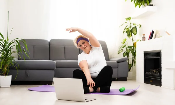 가정 학습. ( 영어 ) Active Senior Woman Making Exersise In Front Of Laptop at Home, Free Space — 스톡 사진