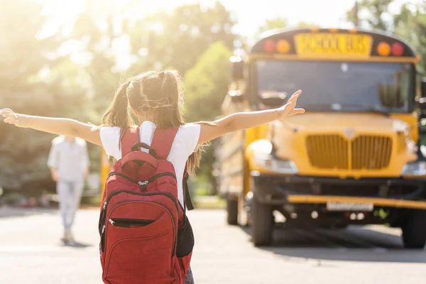 Anya elhozza a lányát az iskolába, közel az iskolabuszhoz. Vissza az iskolába. — Stock Fotó