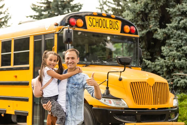 Vader ontmoet kleine dochter die uit de schoolbus komt — Stockfoto