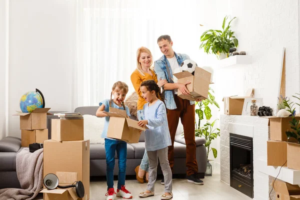 Rodzina z kartonowymi pudełkami stojąca w rzędzie w domu — Zdjęcie stockowe