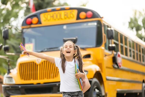 Menina com mochila perto de ônibus escolar amarelo. Transporte para estudantes — Fotografia de Stock