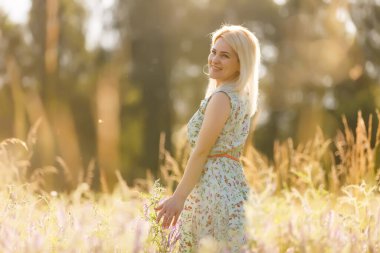 Altın çimenlere dokunan bir kadının eli