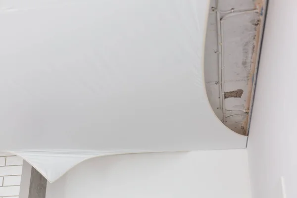 Réparateurs installent plafond tendu en film vinyle pvc à l'aide d'un pistolet à gaz — Photo