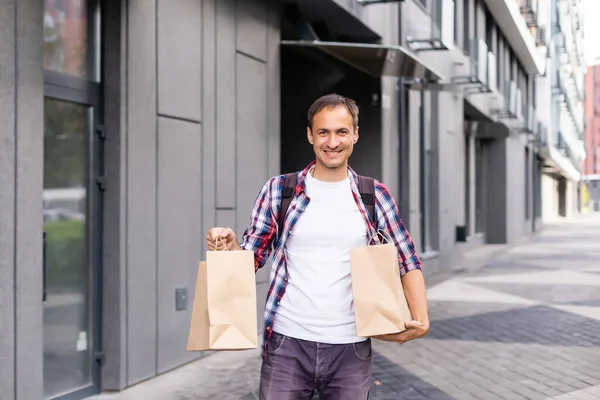 Delivery man with paper containers for takeaway food. — Stock Photo, Image