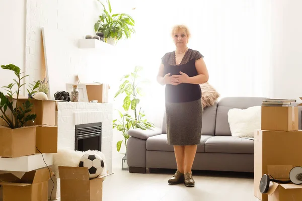 Heureux excité mature retraité femme d'âge moyen debout dans le salon moderne intérieur seul avec les bras tendus profiter de la liberté et le bien-être se sentir motivé à nouveau meublé concept de maison rénovée — Photo