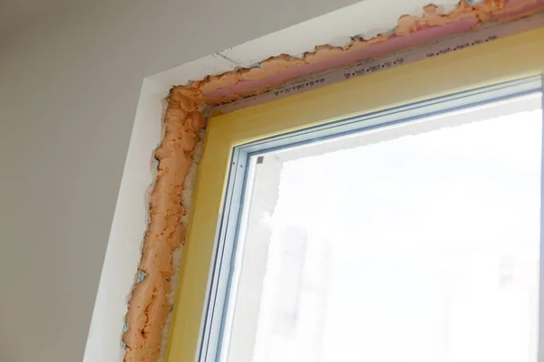 Reparación en las pendientes de la ventana. El proceso de aplicación de una capa de yeso en los lados de la ventana. — Foto de Stock