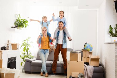 Taşındığı gün yeni evde karton kutuları olan mutlu bir aile..