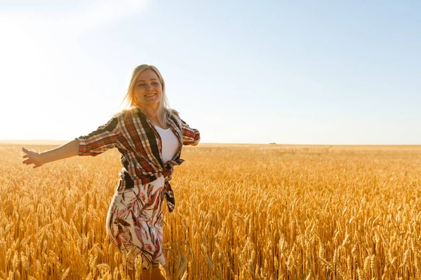 Una ragazza in mezzo a spighe di grano. donna caucasica posa con spighette al di fuori. — Foto Stock