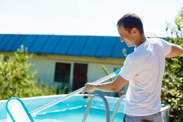 Hombre limpiando la piscina en su casa de campo. Concepto de verano en casa. Estilo de vida —  Fotos de Stock
