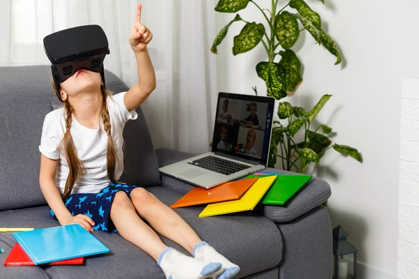 Yeni teknolojiler deniyorum. Büyük video gözlüklü küçük kız sanal oyunlar oynarken etkileniyor. Ev okulu, çevrimiçi eğitim, ev eğitimi, karantina konsepti - Görüntü — Stok fotoğraf