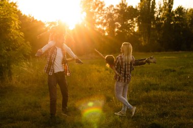 Doğada gün batımında mutlu bir aile