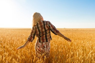 Buğday dikenlerinin ortasında bir kız. Kafkasyalı kadın dikenli çubuklarla dışarıda poz veriyor..