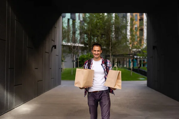 Lieferung, Post und Menschen-Konzept - glücklicher Mann, der Lebensmittel in Einweg-Papiertüten nach Hause bringt — Stockfoto