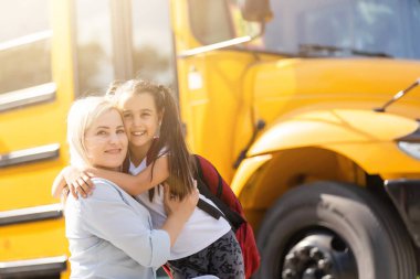 Anne kızını okula götürüyor, bugünlük hoşça kal diyor.