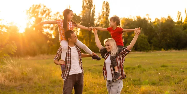 Bonne famille au coucher du soleil dans la nature — Photo