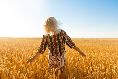 Buğday dikenlerinin ortasında bir kız. Kafkasyalı kadın dikenli çubuklarla dışarıda poz veriyor..