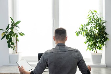 Gülümseyen genç serbest çalışan, dizüstü bilgisayar kullanan, online çalışan, evden çalışan, mutlu, bilgisayar başında yazan, internette sörf yapan, uzak işlerden keyif alan,.