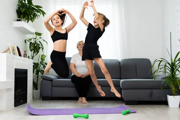 Grandmother and children exercising workout at home near the window in room — Stock Photo, Image
