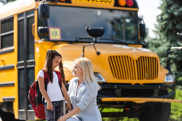 Mamá lleva a su hija a la escuela cerca del autobús escolar. de vuelta a la escuela — Foto de Stock