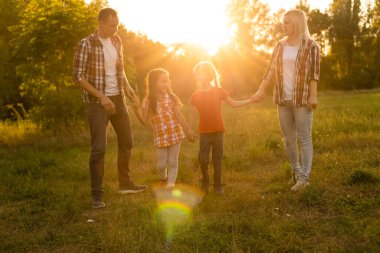 Doğada gün batımında mutlu bir aile