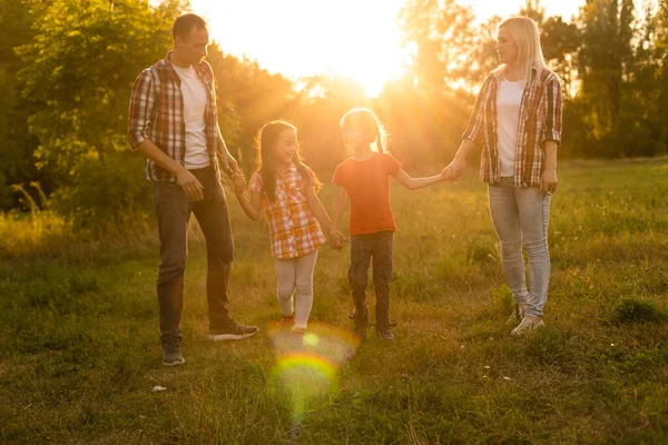 Щаслива сім'я на заході сонця в природі — стокове фото
