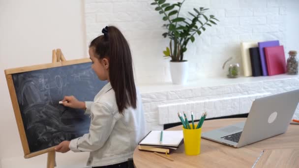Kleine Schulmädchen schreiben Briefe an die Tafel. Kleinkind Mädchen mit Kreide und Zeichnung. — Stockvideo