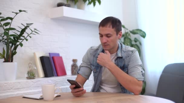 Überraschter und schockierter Mann blickt auf Smartphone-Bildschirm — Stockvideo