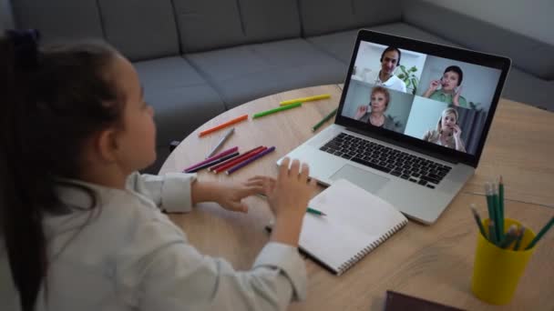 Menina inteligente aprende on-line em um laptop, chat de vídeo em casa, educação distante — Vídeo de Stock