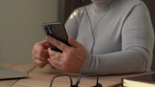 Eine ältere Frau hält ihr Handy in der Hand. Senioren mit Smartphone. Kommunikationstechnologisches Konzept — Stockvideo