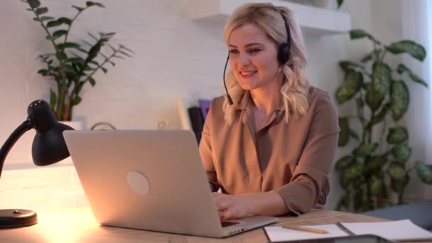 Sonriente joven mujer de negocios profesional hablando con el ordenador portátil sentarse en el escritorio de la oficina en casa, feliz cliente femenino, confirmando el concepto de entrega de pedidos de compras en línea sitio web — Vídeos de Stock