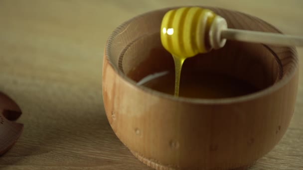 厚い蜂蜜はスプーンから滴り落ち、閉じます。スプーンから蜂蜜が流れる — ストック動画