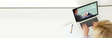 Bilgisayarının önündeki kadın terapistiyle çevrimiçi görüşme yapıyor.