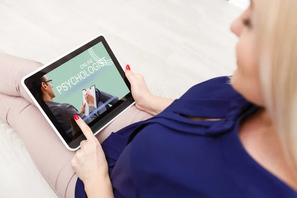 A young woman sits and calls an online psychologist during home quarantine. Video call to the doctor on a digital tablet. — Stock Photo, Image