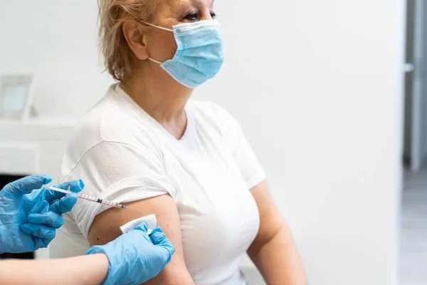 Mujer mayor recibiendo una vacuna contra la gripe porcina — Foto de Stock