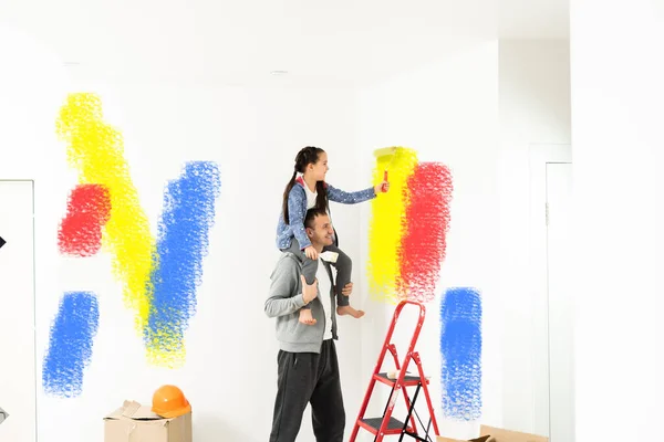 Família, filha feliz com o pai fazendo reparação em casa, paredes de pintura, juntamente com o amor — Fotografia de Stock
