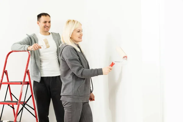 Feliz bela jovem fazendo pintura de parede — Fotografia de Stock