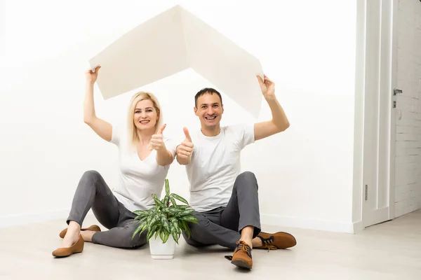 Happy family sitting together and making the home sign — Stock Photo, Image