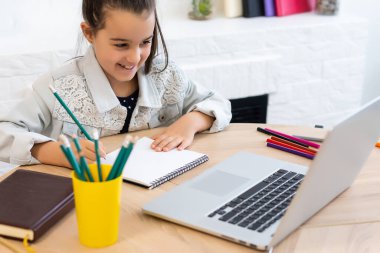 Coronavirüs salgını sırasında evden e-öğrenim platformu kursuna katılan küçük bir kız..