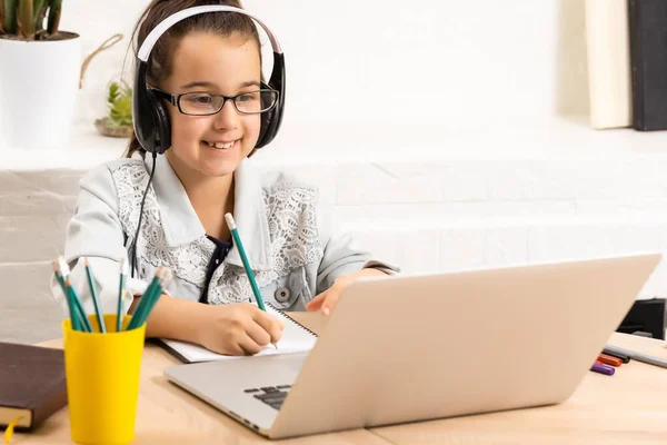Kind online. Een klein meisje maakt gebruik van een laptop video chat om te communiceren leren terwijl thuis zitten. — Stockfoto